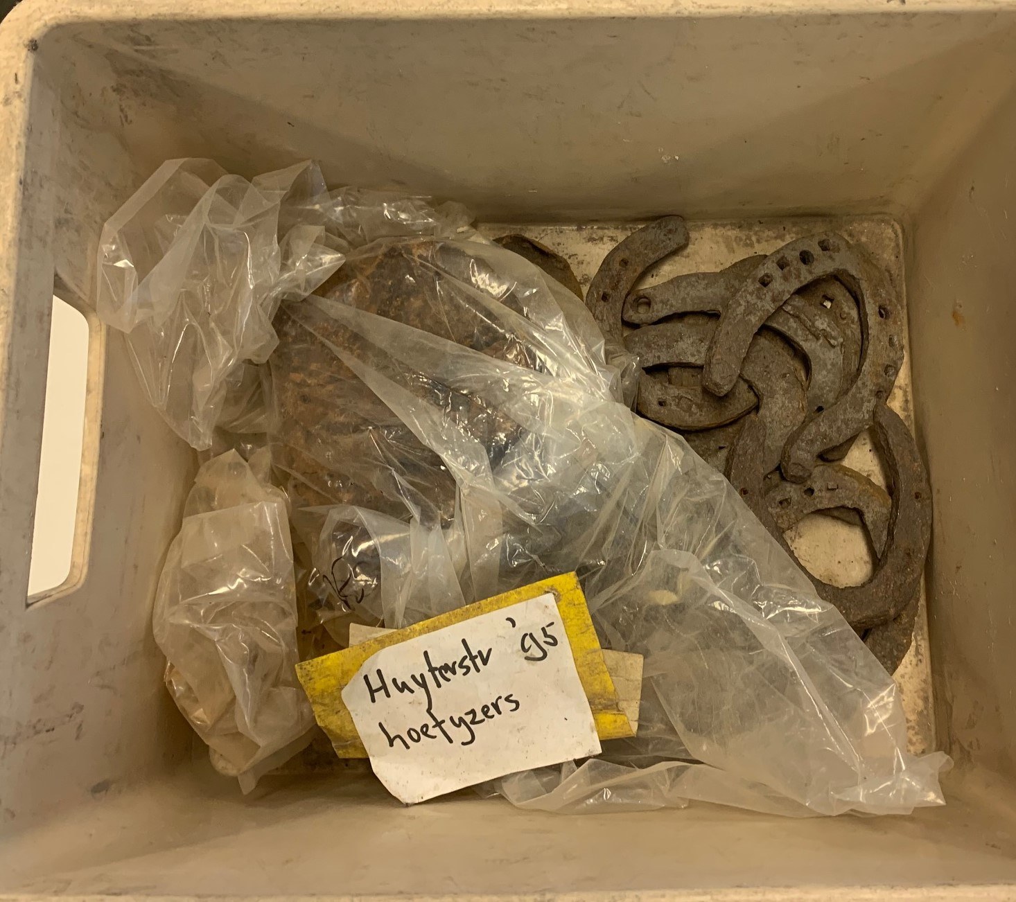 Hoefijzers in een plastic zak en doos als archeologische vondsten uit de Huzterstraat in Delft.