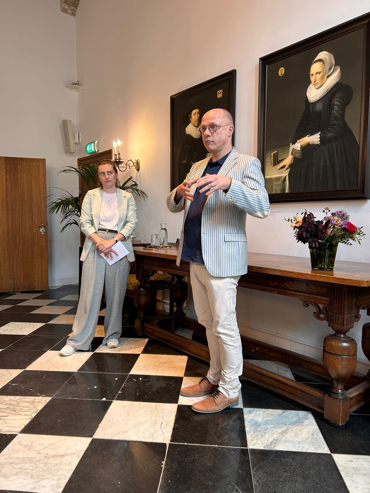 Medewerkster Educatie van Erfgoed Delft en presentator in een historische ruimte van het stadhuis Delft.