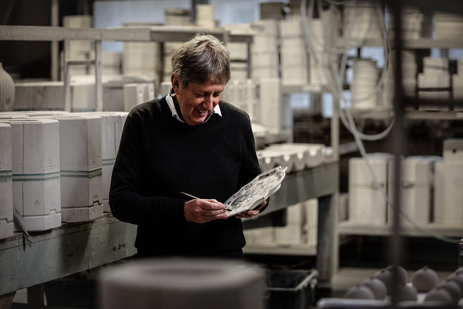 Martin Kremers schildert een bord in de Royal Delft fabriek.